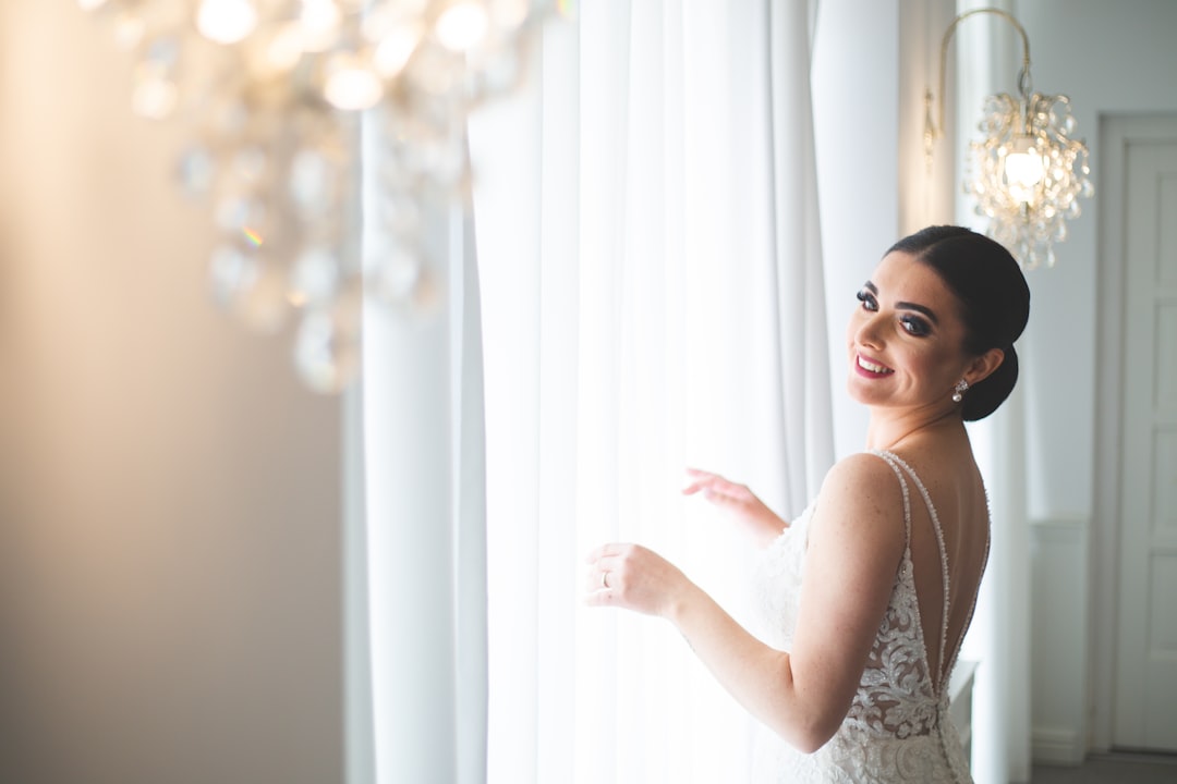 Bride happily browsing a rack of elegant gowns in a sunlit boutique