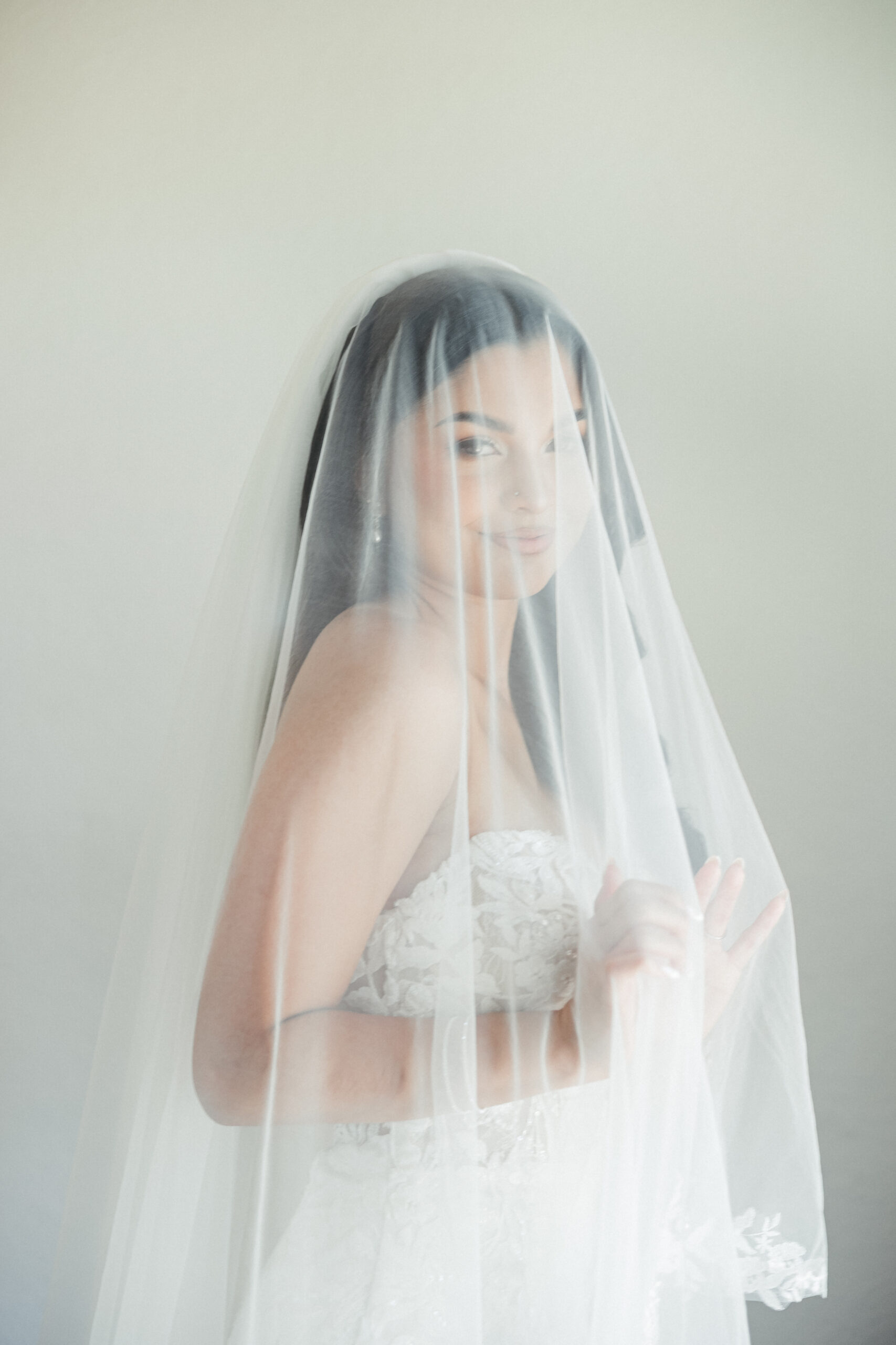 bride smiling in a beautiful wedding gown at a bridal boutique